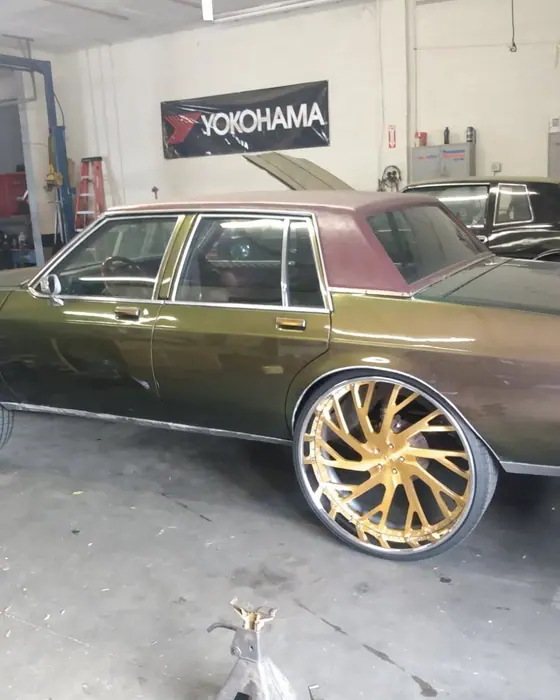 A car up on jack stands in the bay with the wheels off the ground