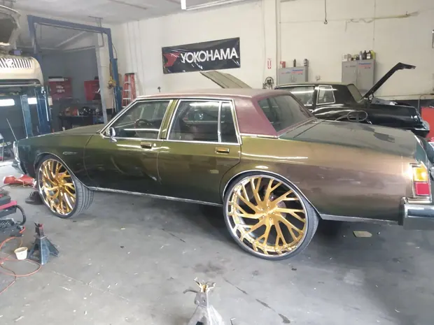 A car up on jack stands in the bay with the wheels off the ground