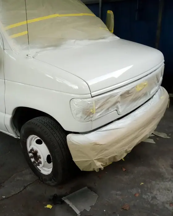 A white box truck masked up at the front end for paint