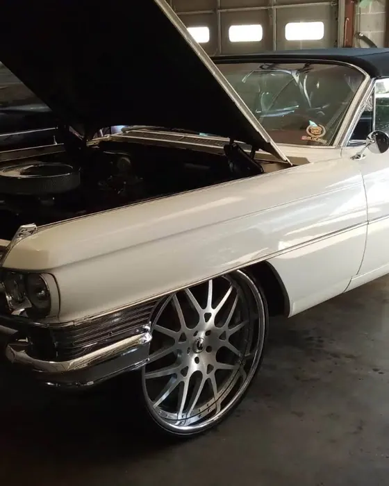A 1964 Cadillac convertible with the hood up in the shop