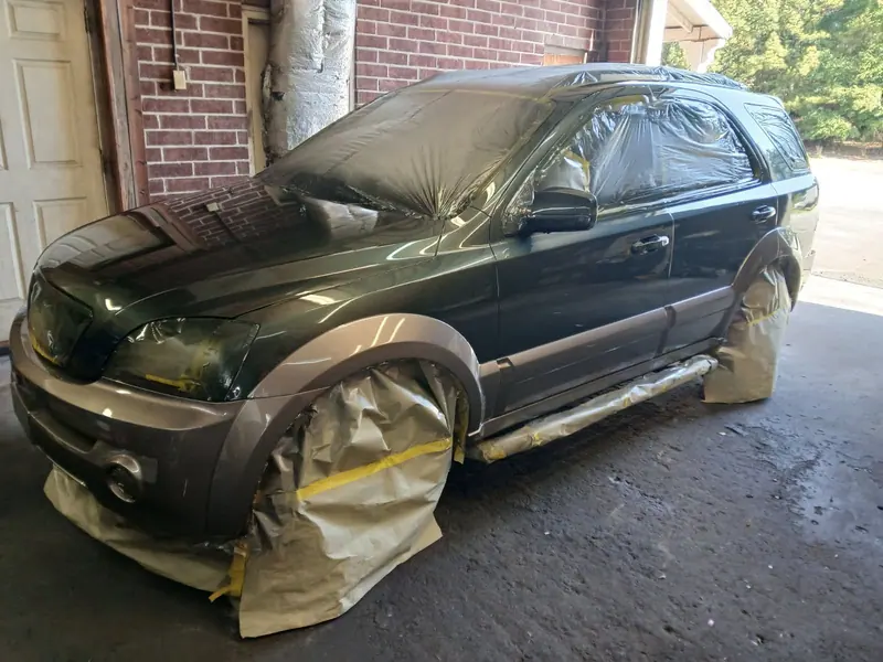 An SUV masked off with paper, plastic and tape, ready for paint