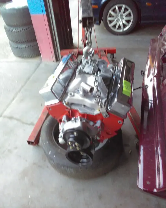 A V8 on the hoist, on its way back into the car