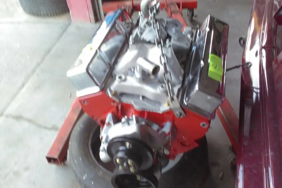 A V8 on the hoist, on its way back into the car